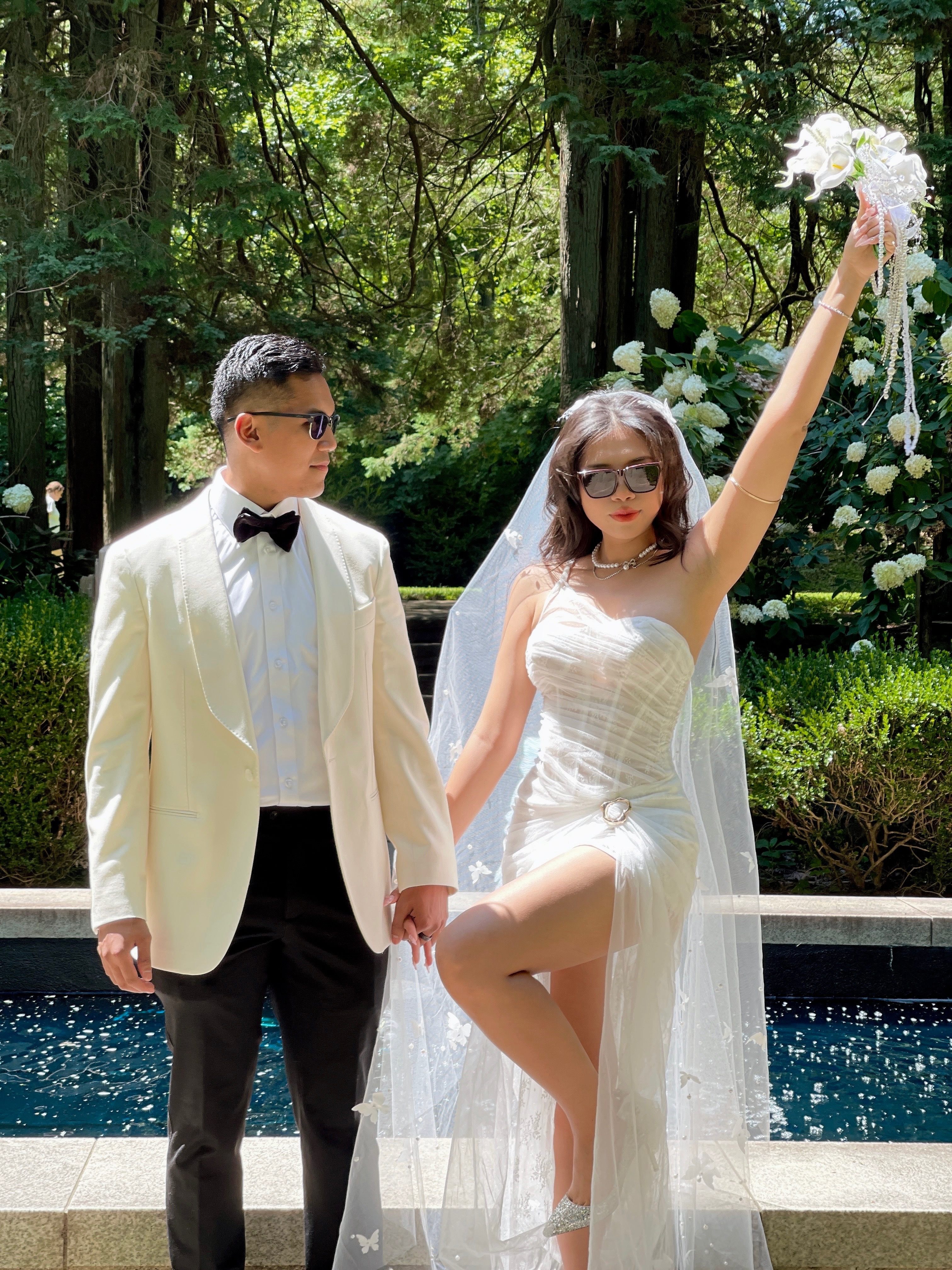 Aldo and Thư celebrating with bouquet by the pool