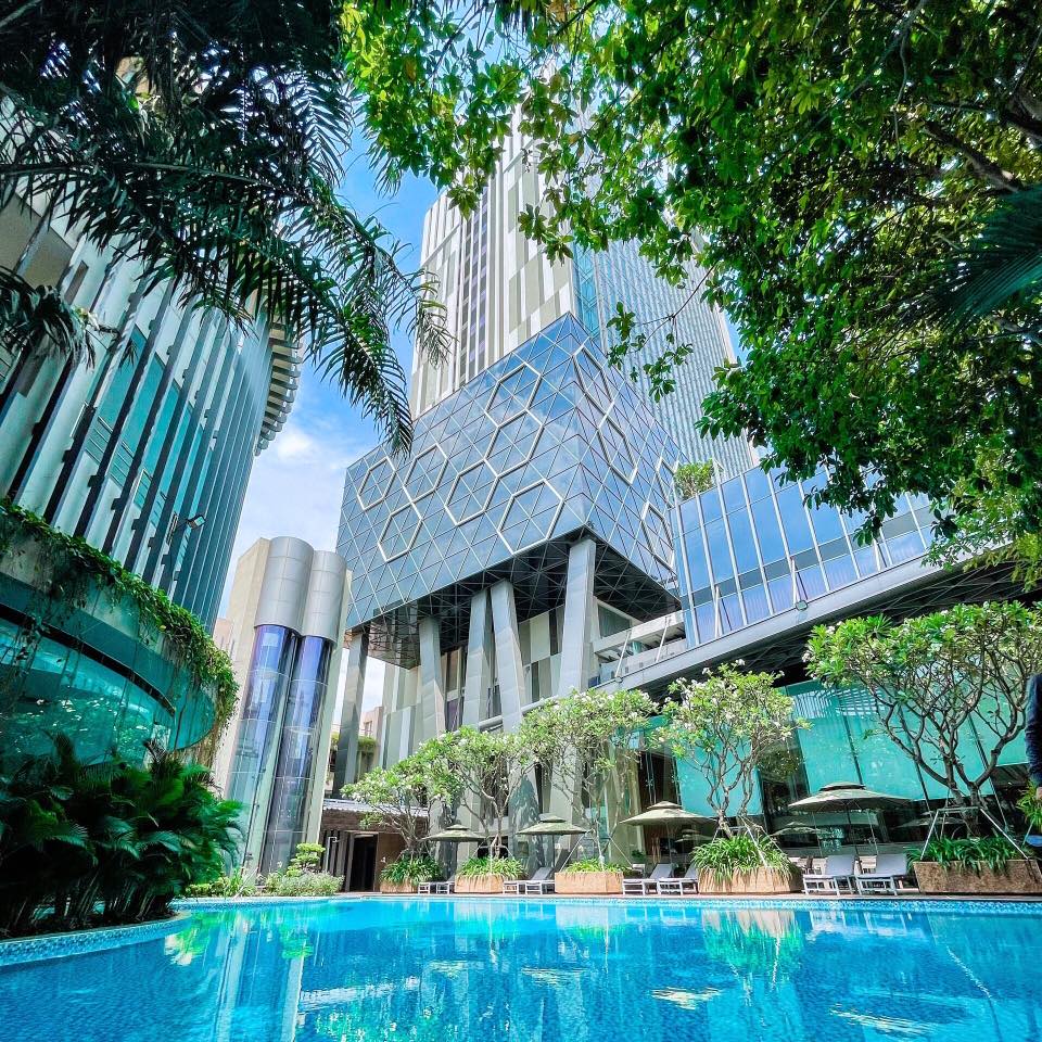 The Mira Central Park hotel exterior — modern hexagonal-cube architecture with multi-story tower and pool