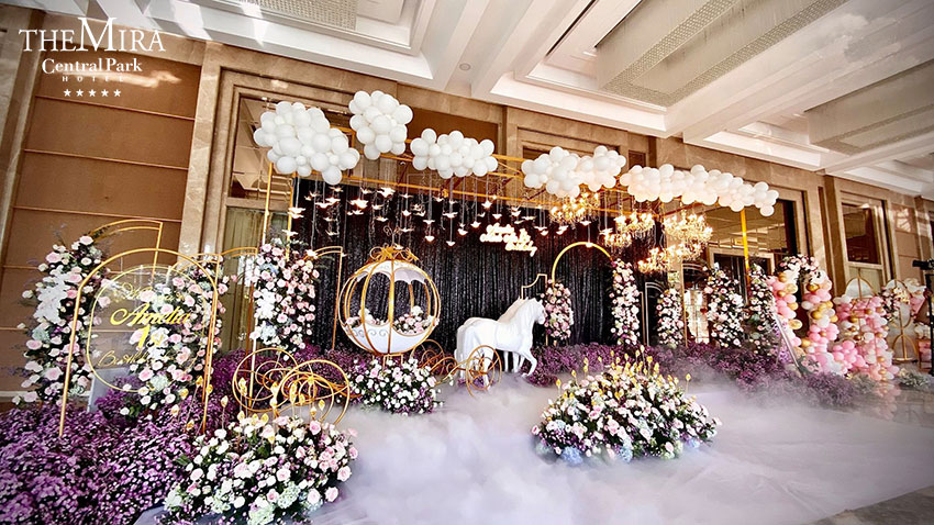 Wedding ceremony backdrop with floral arch, balloons and Mira Central Park branding